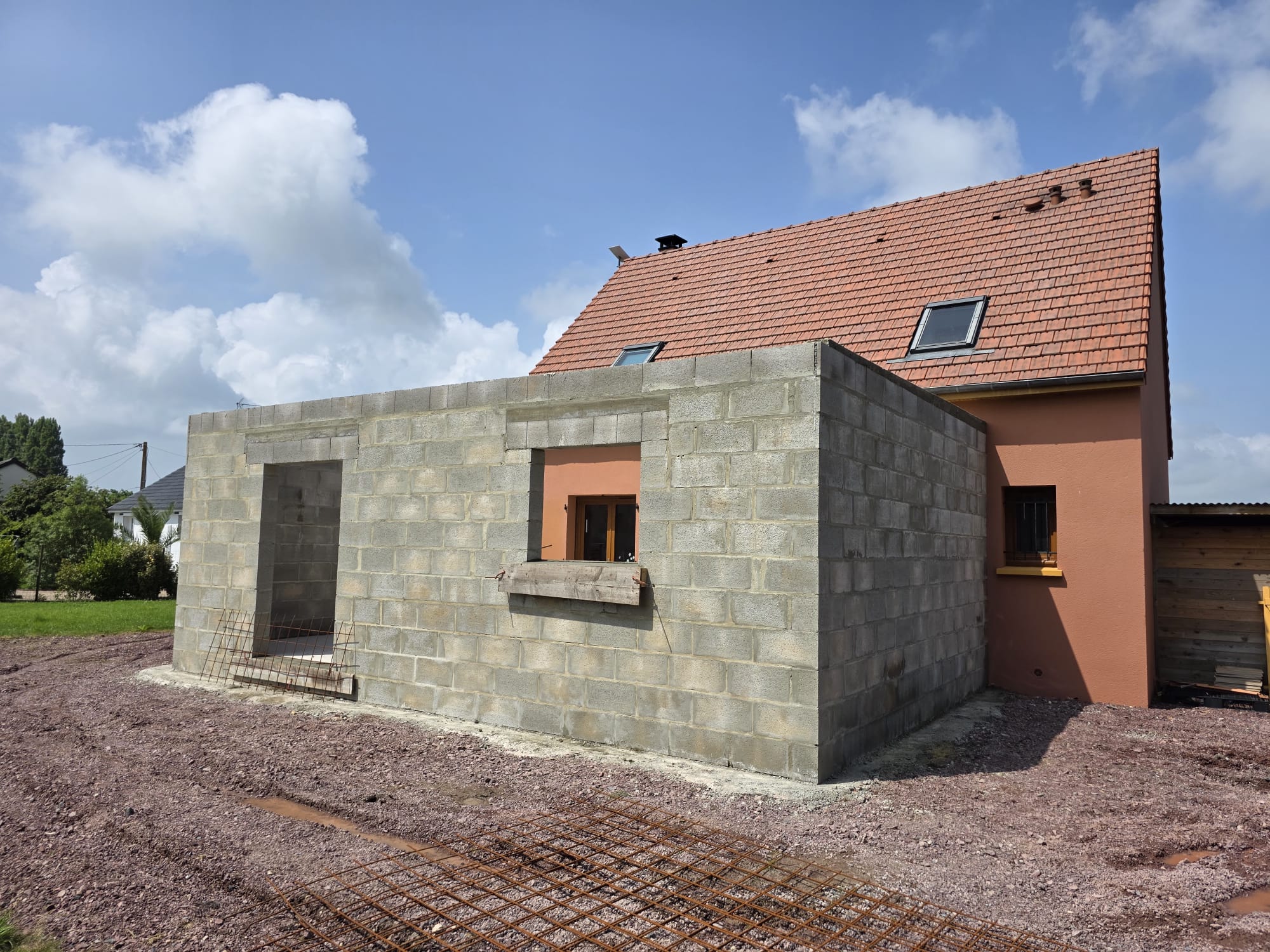 Extension en parpaings accolée à une maison avec toiture tuiles rouges - LR Rénovation