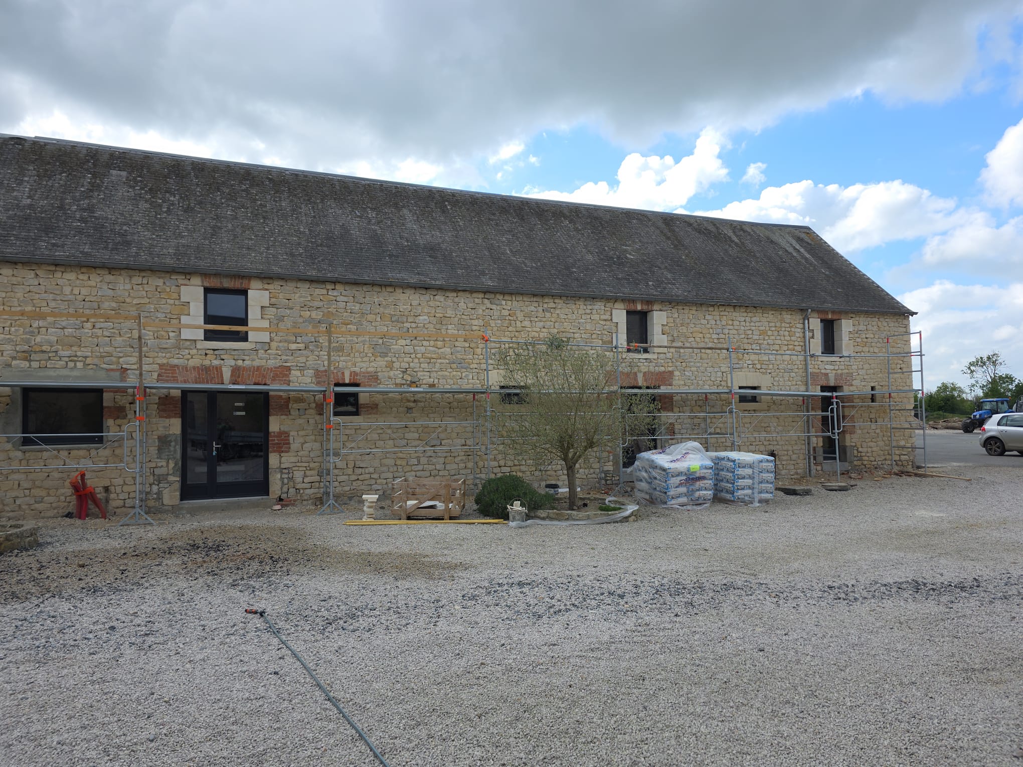 Façade en pierre d'une grande maison en cours de rénovation avec échafaudage - LR Rénovation