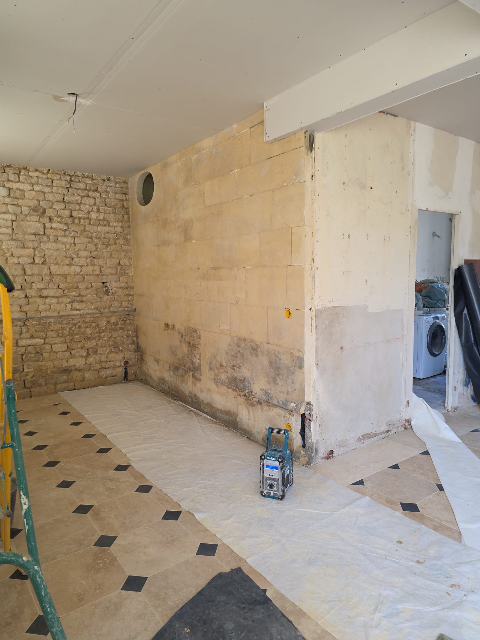 Intérieur en rénovation avec murs en pierre et carrelage au sol - LR Rénovation