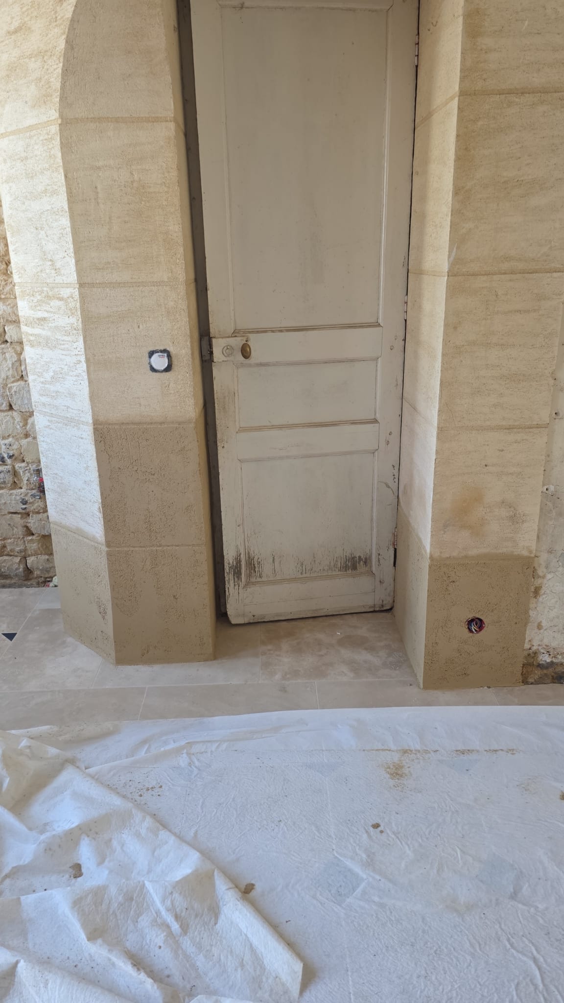 Porte en bois ancienne rénovée avec murs en enduit gris - LR Rénovation