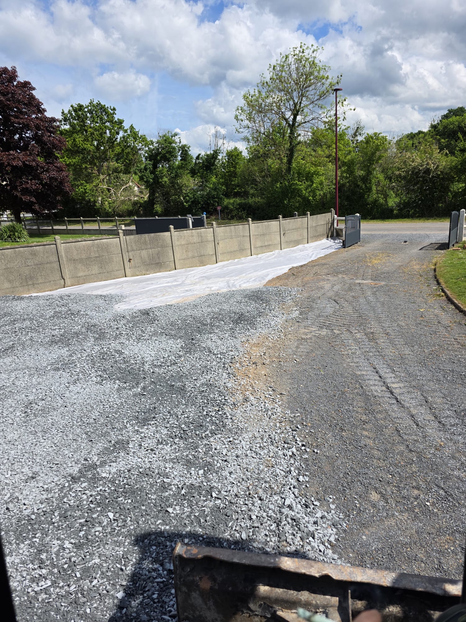 Surface en préparation avec gravier près d'une clôture en béton - LR Rénovation