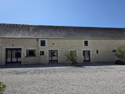 Façade en pierre rénovée avec fenêtres et portes vitrées noires - LR Rénovation Lison