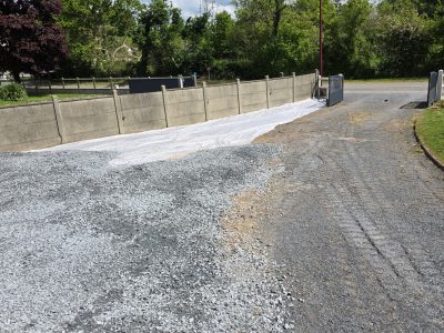 Surface en préparation avec gravier près d'une clôture en béton - LR Rénovation
