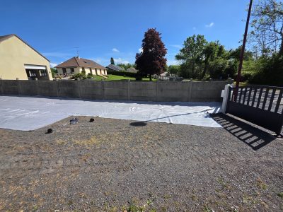 Terrain préparé avec géomembrane blanche devant portail noir - LR Rénovation